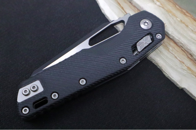 Microtech MSI Manual Folder - Black Two-Toned Finished Blade with Partial Serrate / Fluted Black G-10 Handle 210-2FLGTBK