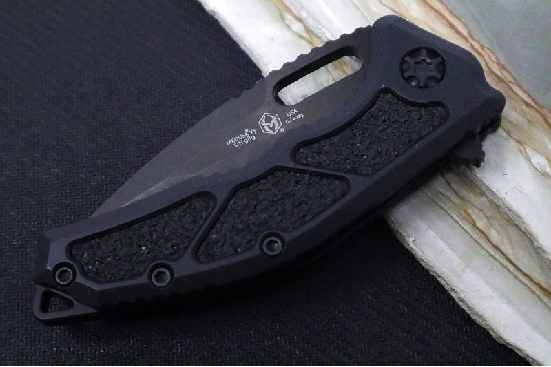 Heretic Knives Medusa Manual Flipper - Recurve Blade / CPM-Magnacut Steel / Black Anodized Aluminum Handle with Black Grip-Tape Inlays / Black Tactical DLC Finished Blade and Hardware H010-6A-T