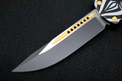 Microtech Hera "Source" Signature Series OTF - Single Edge Style / Two-toned Black Blade with Gold Accents / Black Aluminum Handle with "Source" Artwork 703-TSOS